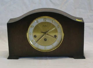 A 1950's 8 day striking mantel clock with gilt dial and Arabic numerals contained in an arched oak case