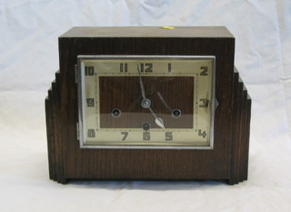 A 1930's 8 day striking mantel clock with square dial and Arabic numeral contained in an oak case