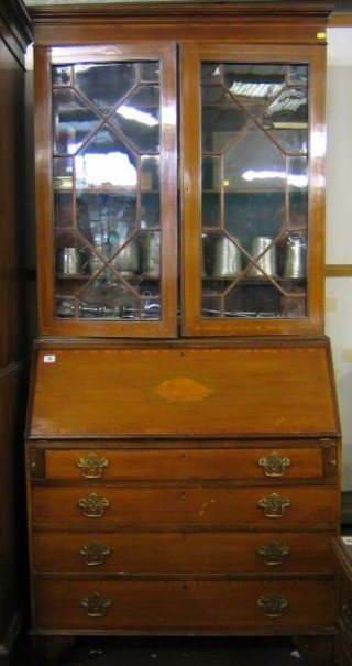An  Edwardian inlaid mahogany bureau bookcase, the upper section with moulded cornice, the shelved interior enclosed by astragal glazed panelled doors, the fall front revealing a well fitted interior above 4 long drawers with pierced brass plate drop handles, raised on bracket feet 36"