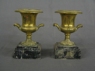 A pair of 19th Century brass urns of campanular form raised on square black marble bases 9"