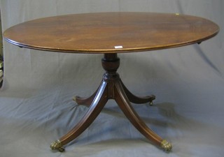 A Georgian style oval mahogany snap top breakfast table raised on pillar and tripod supports 51"