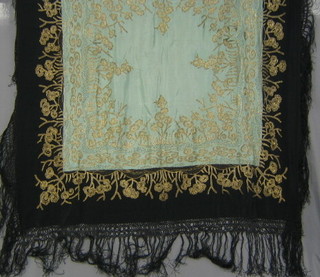 A black and gold lace piano throw with fringe