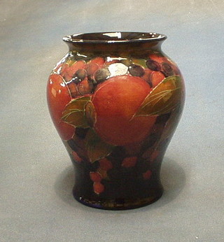 A Moorcroft pomegranate pattern baluster shaped vase, the base impressed Moorcroft and with signature mark, having 1/2" chip to base 7"