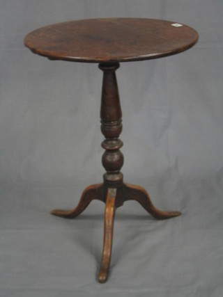 An 18th/19th Century circular oak snap top wine table, raised on a turned column and tripod supports 20"