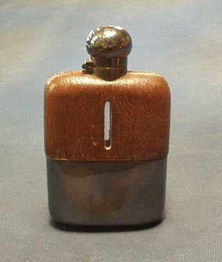 A glass and leather hip flask with silver plated detachable cup
