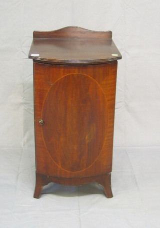 A 19th Century style bow front bedside cabinet enclosed by a panelled door, raised on bracket feet, 16"