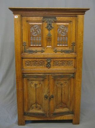 A carved oak cocktail cabinet with fall front above 1 long drawer, the base fitted a drawer with linen fold decoration 36"