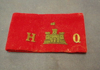 A red arm band with crown marked HQ