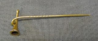 A "gold" stick pin in the form of a hunting horn