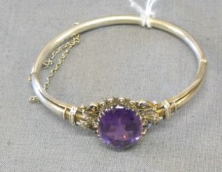 An Edwardian silver bracelet set an oval cut amethyst supported by demi-pearls