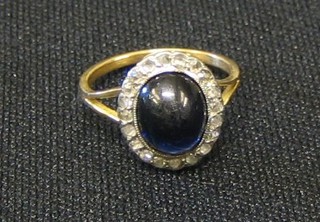 A lady's gold dress ring set a cabouchon cut sapphire surrounded by diamonds