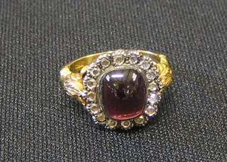 A 15ct gold dress ring set cabouchon cut garnet surrounded by diamonds