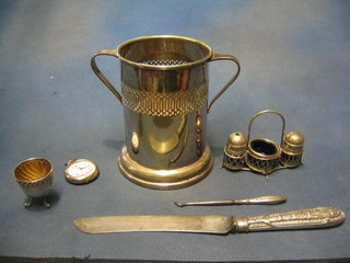 A pierced cylindrical silver plated soda siphon holder, a silver button hook, a silver plated egg cup, a 3 piece condiment set, a bread knife with plated handle and an open faced pocket watch