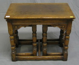 A nest of 3 carved oak interfitting coffee tables, raised on turned and block supports 24"