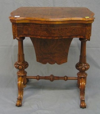 A Victorian figured walnutwood games/work table of serpentine outline, with flap over top inlaid a chessboard, cribbage board and backgammon board, the base fitted 1 long drawer above a deep basket, raised on bulbous turned supports united by an H framed stretcher 24"