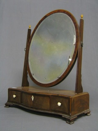 A Georgian oval bevelled plate dressing table mirror contained in a mahogany swing frame, the base of serpentine outline, fitted 1 long and 2 short drawers with ivory escutcheons and handles, raised on ogee bracket feet 19"