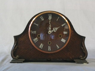 A 1930's 8 day chiming mantel clock with Roman numerals contained in an oak arched case