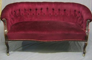 A Victorian mahogany show frame Chesterfield style sofa upholstered in red buttoned material and on cabriole supports 60"