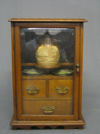 An Edwardian honey oak smoker's cabinet fitted 2 short and 2 long drawers, containing a Doulton Lambeth tobacco jar and cover and 2 porcelain and pewter bordered ashtrays
