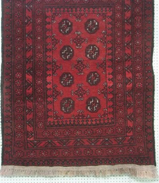 A contemporary Afghan rug with 8 octagons to the centre within multi-row borders, 38" x 51"