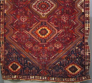 A contemporary red ground and patterned Persian carpet with 3 medallions to the centre within multi-row borders 117" x 68"