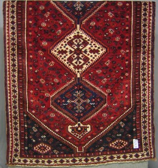 A contemporary red ground Persian carpet having 3 diamonds to the centre with lozenge field within multi-row borders 96" x 61"