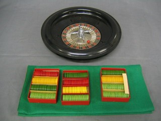 A circular plastic roulette wheel complete with cloth and 3 boxes of plastic game counters
