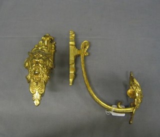A pair of 19th/20th Century gilt metal curtain tie backs in the form of mythical beasts