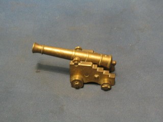A brass model canon with 5" barrel, raised on a brass trunion