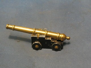 A brass model canon with 6 1/2" barrel, raised on a metal stepped trunion