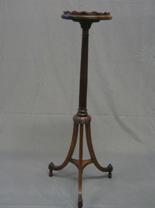A Georgian style circular mahogany torchere stand, raised on a turned and fluted column