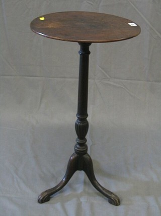 A 19th Century circular mahogany wine table raised on a turned column and tripod supports 15"
