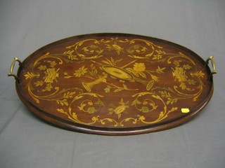 An Edwardian oval inlaid mahogany twin handled tea tray decorated musical instruments within swags, 25"