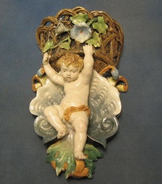 A 19th Century Majolica wall pocket in the form of a cherub supporting a basket 12"
