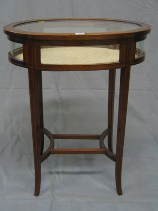 An Edwardian oval inlaid mahogany bijouterie table with hinged lid, raised on outswept supports united by a stretcher 24"