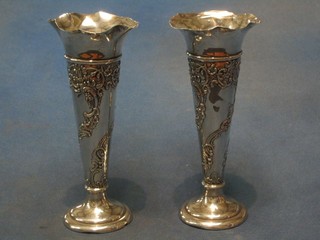 A pair of Edwardian embossed silver trumpet shaped specimen vases, raised on circular spreading feet, London 1910 7"