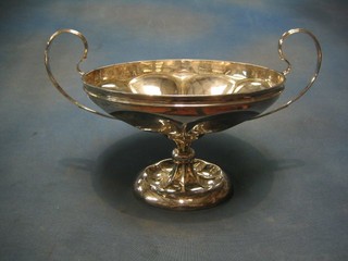 A circular silver twin handled bowl with shaped body, raised on a circular foot, Sheffield 1912 by Walker & Hall, 27 ozs