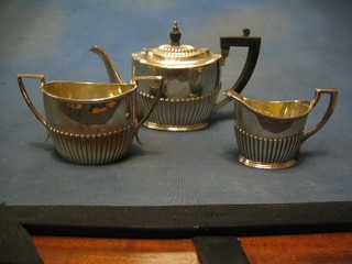 A 3 piece Britannia metal tea service of oval form with demi-reeded decoration comprising teapot, cream jug, twin handled sugar bowl