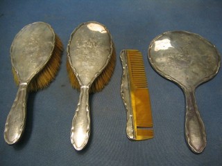 A silver backed hand mirror, pair of hair brushes and comb, Birmingham 1915, monogrammed CH