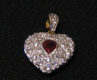 A lady's gold heart shaped pendant, set a heart cut ruby surrounded by numerous diamonds (approx 0.80ct)