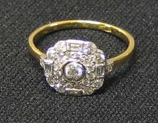 A lady's gold dress ring set a circular cut diamond supported by 4 baguette cut diamonds and numerous other diamonds (approx 0.65ct)