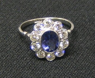 A lady's gold dress ring set a large oval cut Tanzanite, surrounded by 10 diamonds