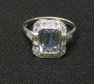 A lady's white gold dress ring set a rectangular cut aquamarine supported by 2 baguette cut diamonds and numerous other diamonds and 6 diamonds to the shoulders (approx 0.52ct)