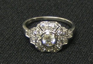 A lady's white gold dress ring set a circular cut diamond, surrounded by numerous diamonds (approx 0.63ct)