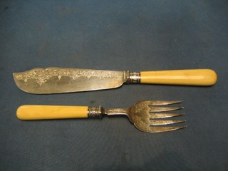 A pair of Victorian silver fish servers with engraved blades and ivory handles, Sheffield 1880