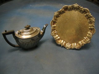 An oval Britannia metal teapot with demi-reeded decoration and a silver plated salver with bracketed border, raised on panelled supports 11"
