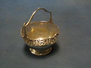 A circular pierced silver bon bon dish with cast handle, raised on a circular spreading foot, Birmingham 1929, by Mappin & Webb, 2 ozs