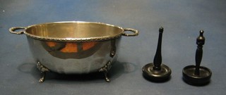 An oval silver plated twin handled bowl, raised on 4 hoof supports 10" and 2 ebony ring trees