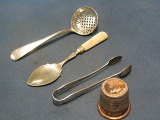 A pair of silver sugar tongs, a silver plated sifter spoon, a silver plated copper measure in the form of a thimble and a silver jam spoon