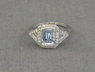 A lady's white gold dress ring set a rectangular cut aquamarine supported by numerous diamonds